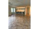 Spacious living room with tan tile flooring, leading into an open kitchen with a breakfast bar and seating at 3790 Cadbury Cir # 40, Venice, FL 34293