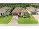 Aerial view of a home with a brick driveway, well-manicured lawn, and lush landscaping at 4740 Royal Dornoch Cir, Bradenton, FL 34211