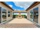 Paver patio with an outdoor brick fireplace and landscaped garden in backyard at 4740 Royal Dornoch Cir, Bradenton, FL 34211