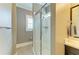 Bathroom featuring a walk-in shower with glass enclosure, window, and a dark vanity with a framed mirror at 4740 Royal Dornoch Cir, Bradenton, FL 34211