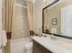Elegant bathroom with a decorative mirror, modern vanity, and a tub with a patterned tile backsplash at 4740 Royal Dornoch Cir, Bradenton, FL 34211