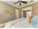Cozy bedroom with a ceiling fan, neutral tones, and a glimpse into an adjacent sunroom or seating area at 4740 Royal Dornoch Cir, Bradenton, FL 34211