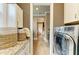 Bright hallway featuring laundry room and pantry access, with ample storage and modern appliances at 4740 Royal Dornoch Cir, Bradenton, FL 34211