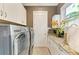 Modern laundry room with a large washer and dryer, white cabinets, and granite countertops at 4740 Royal Dornoch Cir, Bradenton, FL 34211