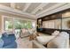 Comfortable living room with coffered ceilings, built-in storage, and access to the outdoor patio area at 4740 Royal Dornoch Cir, Bradenton, FL 34211