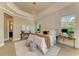 Bright main bedroom features tray ceiling, chandelier lighting and dual side tables at 4740 Royal Dornoch Cir, Bradenton, FL 34211