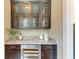 Detailed granite countertop with a built-in wine cooler and decorative glass cabinets at 4740 Royal Dornoch Cir, Bradenton, FL 34211