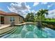 Stunning pool with stone steps, palm trees, and lush landscaping for ultimate relaxation at 4740 Royal Dornoch Cir, Bradenton, FL 34211