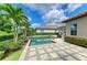Beautiful pool area with lush landscaping, stone decking, and a serene backyard oasis, ideal for relaxation and entertaining at 4740 Royal Dornoch Cir, Bradenton, FL 34211