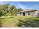 Spacious backyard with a well-maintained lawn, mature trees, and the home's exterior at 4890 Laramie Cir, North Port, FL 34286