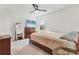 Cozy bedroom with a ceiling fan, neutral carpet and walls, and a large window providing natural light at 4890 Laramie Cir, North Port, FL 34286
