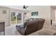 Comfortable living room with a reclining leather sofa, ceiling fan, and sliding glass doors to the backyard at 4890 Laramie Cir, North Port, FL 34286