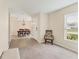 Open-concept living room featuring neutral carpet, tile entryway, and dining area with chandelier at 4890 Laramie Cir, North Port, FL 34286