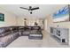 View of the open-concept living room featuring a sectional sofa, ceiling fan, and direct access to the kitchen area at 4890 Laramie Cir, North Port, FL 34286