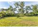 Large, lush yard with mature trees and tropical landscaping offers privacy and shade at 4890 Laramie Cir, North Port, FL 34286