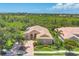 Aerial view of single-Gathering home with lush greenery shows curb appeal and surrounding landscape at 5018 Bella Terra Dr, Venice, FL 34293