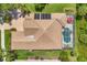Aerial view of home featuring private pool, lanai, mature landscaping, and brick driveway at 5018 Bella Terra Dr, Venice, FL 34293