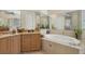 Bathroom featuring soaking tub, glass enclosed shower, and vanity area at 5018 Bella Terra Dr, Venice, FL 34293