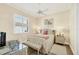 Cozy bedroom with a queen-sized bed, wicker furniture, neutral walls, and plenty of natural light at 5018 Bella Terra Dr, Venice, FL 34293