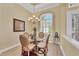 An arched dining area featuring a circular glass table and decorative lighting fixture at 5018 Bella Terra Dr, Venice, FL 34293
