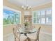Bright dining room features a glass table set and views to the lanai at 5018 Bella Terra Dr, Venice, FL 34293