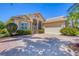 Inviting single-story home with a brick driveway and lush landscaping creates wonderful curb appeal at 5018 Bella Terra Dr, Venice, FL 34293