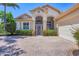 Inviting single-story home with a brick driveway and lush landscaping creates wonderful curb appeal at 5018 Bella Terra Dr, Venice, FL 34293