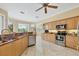 Kitchen with stainless steel appliances, maple cabinetry, and breakfast bar area at 5018 Bella Terra Dr, Venice, FL 34293