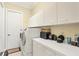 Clean laundry room with white washer and dryer, white cabinets, and neutral walls at 5018 Bella Terra Dr, Venice, FL 34293