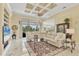 Bright living room boasts a tray ceiling, tile floors and a large sectional sofa at 5018 Bella Terra Dr, Venice, FL 34293