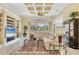 Bright living room featuring a large sectional sofa, custom built-ins, and decorative ceiling at 5018 Bella Terra Dr, Venice, FL 34293