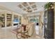 Spacious living room featuring custom built-ins, a decorative tray ceiling, and abundant natural light at 5018 Bella Terra Dr, Venice, FL 34293