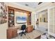 Home office with custom shelving, granite desk, and glass French doors at 5018 Bella Terra Dr, Venice, FL 34293