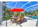Screened patio with outdoor dining area beside a private pool overlooking the backyard at 5018 Bella Terra Dr, Venice, FL 34293