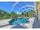 Private screened-in pool and spa with waterfall feature, surrounded by lush landscaping and tropical foliage at 5018 Bella Terra Dr, Venice, FL 34293