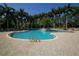 Beautiful community pool with wading area, lounge chairs, and lush landscaping at 5018 Bella Terra Dr, Venice, FL 34293