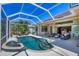 Beautiful screened-in pool and spa area with ample seating and covered patio at 5018 Bella Terra Dr, Venice, FL 34293