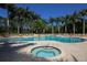 Resort-style pool and spa surrounded by tropical landscaping and lounge chairs at 5018 Bella Terra Dr, Venice, FL 34293
