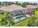 Aerial shot of a lovely pool and lanai with manicured landscaping at 5018 Bella Terra Dr, Venice, FL 34293