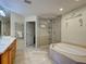 Luxurious bathroom boasts a soaking tub, glass shower, and vanity with granite countertop at 516 Tamiami S Trl # 303, Nokomis, FL 34275
