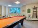 Relaxing billiards room featuring an orange felt pool table, comfortable seating, and scenic waterfront views at 516 Tamiami S Trl # 303, Nokomis, FL 34275