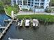 Aerial view of private boat docks beside a condo building, offering convenient waterfront access and boat storage at 516 Tamiami S Trl # 303, Nokomis, FL 34275
