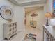 Bright and inviting condo foyer featuring decorative furniture, a large mirror, and art at 516 Tamiami S Trl # 303, Nokomis, FL 34275