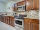 Updated kitchen with stainless steel oven, microwave, granite counters, and backsplash at 516 Tamiami S Trl # 303, Nokomis, FL 34275