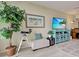 Bright living room with stylish turquoise console, large TV, comfortable ottoman and accents, near a large plant at 516 Tamiami S Trl # 303, Nokomis, FL 34275