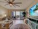 A living room with a large flat-screen TV, comfortable seating, and sliding doors leading to a balcony with water views at 516 Tamiami S Trl # 303, Nokomis, FL 34275