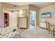 Neutral-toned bedroom with a bookcase, dresser, and adjacent bathroom at 516 Tamiami S Trl # 303, Nokomis, FL 34275