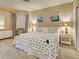 Bright main bedroom featuring a palm tree patterned comforter, soft carpet, and neutral-toned walls at 516 Tamiami S Trl # 303, Nokomis, FL 34275