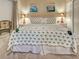 Bright main bedroom featuring a palm tree patterned comforter, soft carpet, and neutral-toned walls at 516 Tamiami S Trl # 303, Nokomis, FL 34275