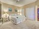 Spacious bedroom with a palm tree patterned comforter, soft carpet, closet, and adjacent bookcase at 516 Tamiami S Trl # 303, Nokomis, FL 34275